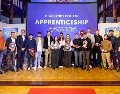 A group photo of apprentices all holding awards and smiling towards the camera.