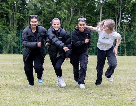 Four Girls Walking Together on a Field